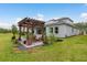 A backyard with a wooden pergola and seating area that invites outdoor living and entertaining at 1771 Whitewillow Dr, Wesley Chapel, FL 33543