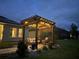 Backyard pergola at twilight, illuminated with string lights creating a cozy outdoor ambiance at 1771 Whitewillow Dr, Wesley Chapel, FL 33543