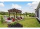 Picturesque backyard pergola overlooking the serene water view, perfect for relaxation at 1771 Whitewillow Dr, Wesley Chapel, FL 33543