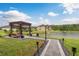 Backyard featuring a lake view, a wood pergola, and beautiful landscaping at 1771 Whitewillow Dr, Wesley Chapel, FL 33543