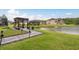 Backyard featuring a lake view, a wood pergola, and beautiful landscaping at 1771 Whitewillow Dr, Wesley Chapel, FL 33543