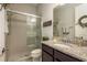 Bathroom featuring a glass-enclosed shower, granite countertop, and modern fixtures at 1771 Whitewillow Dr, Wesley Chapel, FL 33543