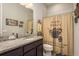 Full bathroom with granite counters, dark wood cabinets, and decorative shower curtain at 1771 Whitewillow Dr, Wesley Chapel, FL 33543