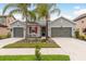 Beautiful two-story home with a three-car garage, well-manicured landscaping, and two palm trees at 1771 Whitewillow Dr, Wesley Chapel, FL 33543
