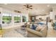 Open-concept living room with lake views from the large windows, with an eat-in kitchen in the background at 1771 Whitewillow Dr, Wesley Chapel, FL 33543
