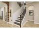 Elegant staircase with dark wood railings and white spindles, complemented by wood-look tile flooring at 1771 Whitewillow Dr, Wesley Chapel, FL 33543