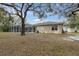Expansive backyard featuring a screened-in pool area, well maintained yard, and mature trees at 18328 Treehaven Dr, Hudson, FL 34667