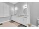 Bathroom featuring a double vanity, framed mirrors, and shuttered window at 18328 Treehaven Dr, Hudson, FL 34667