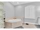 Bathroom with tiled tub, shuttered window and tile surround at 18328 Treehaven Dr, Hudson, FL 34667