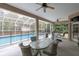 Covered lanai with dining area overlooking screened-in pool and backyard at 18328 Treehaven Dr, Hudson, FL 34667