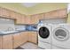 Functional laundry room with ample cabinet storage and a utility sink at 18328 Treehaven Dr, Hudson, FL 34667