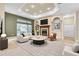 Modern living room with a fireplace, tray ceiling, and access to the outdoor pool area at 18328 Treehaven Dr, Hudson, FL 34667