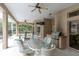 Covered patio with ceiling fans and a dining table, along with an outdoor kitchen and grill at 18328 Treehaven Dr, Hudson, FL 34667