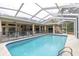 Screened-in pool with a safety fence, offering a private outdoor space with a covered lanai at 18328 Treehaven Dr, Hudson, FL 34667