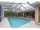 Enclosed pool with a covered patio featuring ceiling fans, a dining table, and backyard at 18328 Treehaven Dr, Hudson, FL 34667