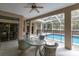 Covered patio features a dining table, ceiling fan, and view of the fenced-in pool at 18328 Treehaven Dr, Hudson, FL 34667
