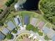 An aerial view of a neighborhood with well-maintained homes, green lawns, mature trees, and a winding street layout at 18456 Merseyside Loop, Land O Lakes, FL 34638