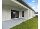 Backyard patio area with sliding doors and a small yard with grass at 18456 Merseyside Loop, Land O Lakes, FL 34638