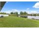 A serene view with a lush green lawn and a tranquil pond lined with trees, creating a peaceful backyard oasis at 18456 Merseyside Loop, Land O Lakes, FL 34638