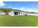 This beautiful backyard features a well-manicured lawn, a sliding glass door to the home, and a white fence for privacy at 18456 Merseyside Loop, Land O Lakes, FL 34638