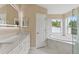 Bathroom featuring white cabinets, quartz counters, a tub, and a walk-in glass shower at 18456 Merseyside Loop, Land O Lakes, FL 34638