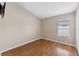 Empty bedroom showcasing hardwood floors and a window with blinds at 18456 Merseyside Loop, Land O Lakes, FL 34638
