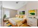 Cozy bedroom design with yellow accents, hardwood floors, and natural lighting at 18456 Merseyside Loop, Land O Lakes, FL 34638