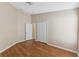 Bedroom with hardwood floors, closet, doorway and overhead lighting at 18456 Merseyside Loop, Land O Lakes, FL 34638