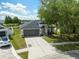 Charming home showcasing a gray roof, neutral paint, a spacious driveway, and a manicured lawn at 18456 Merseyside Loop, Land O Lakes, FL 34638