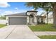 Charming single-story home featuring a manicured lawn, arched entry, and a spacious two-car garage at 18456 Merseyside Loop, Land O Lakes, FL 34638