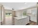 Modern kitchen with white cabinets, stainless steel appliances, island, and a view of the pond at 18456 Merseyside Loop, Land O Lakes, FL 34638