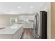 Modern kitchen featuring white cabinetry, stainless steel appliances, and a spacious island at 18456 Merseyside Loop, Land O Lakes, FL 34638
