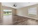 Spacious living room featuring wood floors, large sliding glass doors, and neutral walls at 18456 Merseyside Loop, Land O Lakes, FL 34638