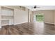 Open living room with hardwood floors, built-in desk, neutral paint, and view of the pond at 18456 Merseyside Loop, Land O Lakes, FL 34638
