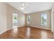 An empty main bedroom, bathed in natural light, showcases wood flooring and ensuite bath at 18456 Merseyside Loop, Land O Lakes, FL 34638
