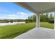 Back patio featuring an expansive view of a grassy field and a pond beyond at 18456 Merseyside Loop, Land O Lakes, FL 34638