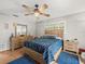 Well-lit bedroom with tile floors, ceiling fan, wooden furniture, and cool paint at 2410 Hammock Pine Blvd # 2410, Clearwater, FL 33761