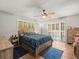 Cozy bedroom features tile floors, wooden furniture, ceiling fan, and sliding glass doors to the outdoor balcony at 2410 Hammock Pine Blvd # 2410, Clearwater, FL 33761