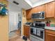 Efficient kitchen layout featuring stainless steel appliances, wood cabinets, and tiled flooring at 2410 Hammock Pine Blvd # 2410, Clearwater, FL 33761