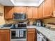 A kitchen featuring wood cabinets, granite countertops, and stainless steel appliances at 2410 Hammock Pine Blvd # 2410, Clearwater, FL 33761