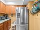 Spacious kitchen featuring stainless steel refrigerator, granite countertops, and wooden cabinets at 2410 Hammock Pine Blvd # 2410, Clearwater, FL 33761