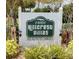 Community sign for Hillcrest Villas, a deed-restricted community with lush landscaping and vintage lighting at 24862 Us Highway 19 N # 203, Clearwater, FL 33763