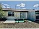 Back exterior view of home with sliding glass doors and turf at 24862 Us Highway 19 N # 203, Clearwater, FL 33763