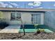 Back exterior view of home with sliding glass doors and turf at 24862 Us Highway 19 N # 203, Clearwater, FL 33763