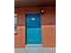 Vibrant blue front door with brick surround and stylish wall-mounted lantern at 24862 Us Highway 19 N # 203, Clearwater, FL 33763