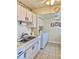 Kitchen area with stainless sink, appliances, and convenient laundry units at 24862 Us Highway 19 N # 203, Clearwater, FL 33763