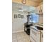 Bright kitchen features a range, tile floors, and a convenient shelving rack at 24862 Us Highway 19 N # 203, Clearwater, FL 33763