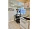 Kitchen area featuring tile floors, range, and a convenient shelving rack at 24862 Us Highway 19 N # 203, Clearwater, FL 33763