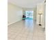 Bright, tiled living room featuring a sliding glass door with view to community at 24862 Us Highway 19 N # 203, Clearwater, FL 33763