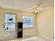 Bright room with tile flooring, exterior door, ceiling fan, and natural light at 24862 Us Highway 19 N # 203, Clearwater, FL 33763